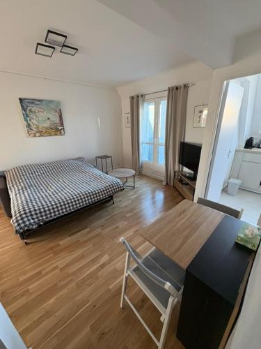 un salon avec un lit, une table et des chaises dans l'établissement Sur les toits de Paris, à Paris