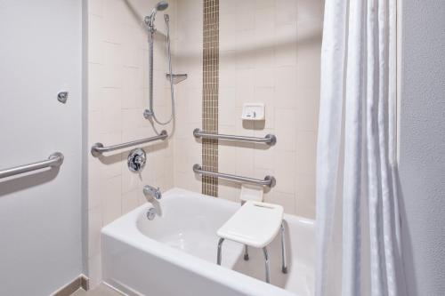 a bathroom with a shower and a toilet and a tub at Candlewood Suites - Cincinnati Northeast - Mason by IHG in Mason