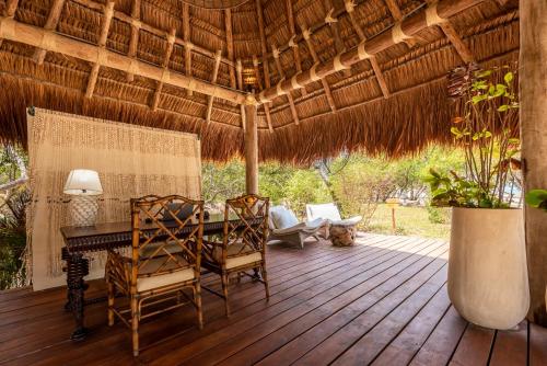 a patio with a table and chairs on a wooden deck at ACASI Rustic Beach in Baru
