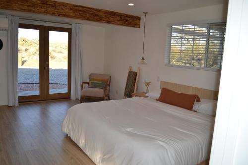 a bedroom with a bed and a sliding glass door at Casa Nova Romantic Desert Escape in Yucca Valley