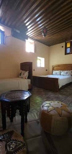 a room with two beds and a table in it at Dawya terrace in Fez