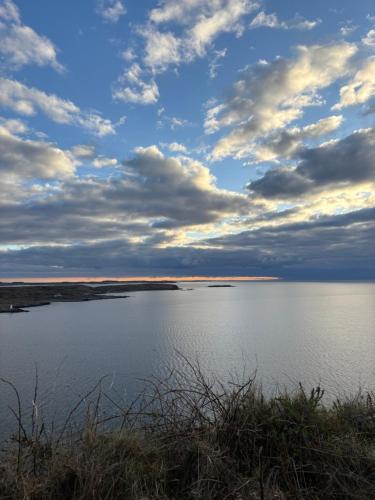 a large body of water with a cloudy sky at Racecourse Lodge Apartment in Clifden