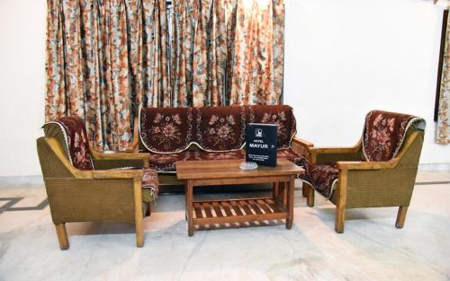 a living room with two chairs and a couch at Hotel Mayur in Gwalior