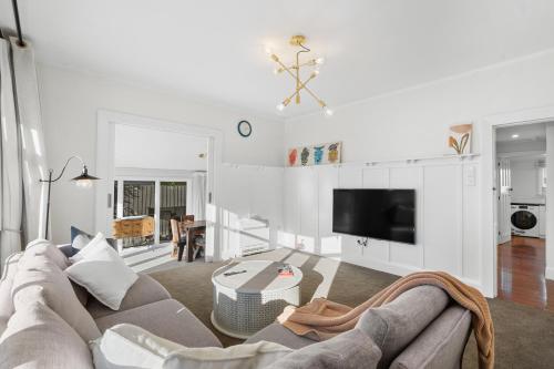 a living room with a couch and a table at City Calm Retreat and A Peaceful Family Haven in Christchurch