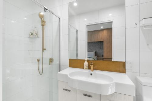 a white bathroom with a sink and a shower at City Calm Retreat and A Peaceful Family Haven in Christchurch