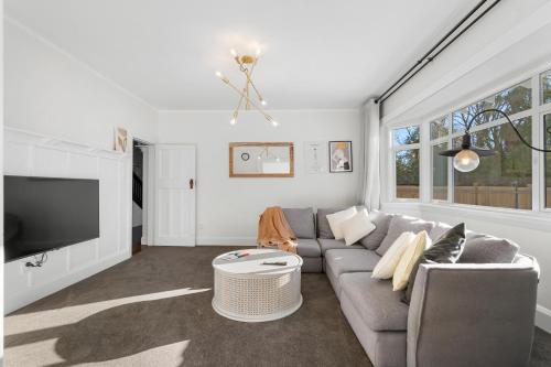 a living room with a couch and a tv at City Calm Retreat and A Peaceful Family Haven in Christchurch