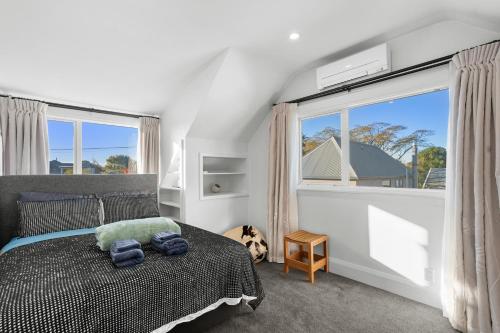 a bedroom with a bed and a large window at City Calm Retreat and A Peaceful Family Haven in Christchurch