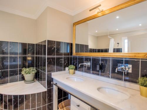 une salle de bain avec deux lavabos et un miroir dans l'établissement La Tropezienne, à Les Brugassières