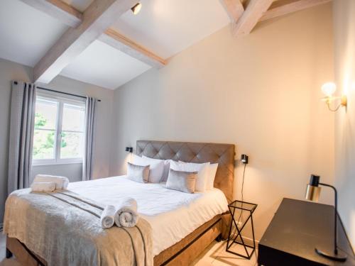 une chambre avec un lit avec des draps blancs et une fenêtre dans l'établissement La Tropezienne, à Les Brugassières