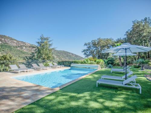 une piscine avec des chaises longues et un parasol dans l'établissement La Tropezienne, à Les Brugassières