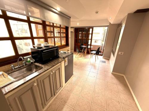 a kitchen with a sink and a microwave at Casa Recoleta - Hoteles Recoleta in Buenos Aires