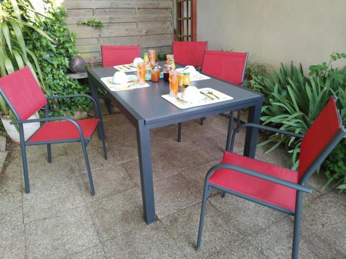 une table entourée de quatre chaises rouges dans l'établissement chez Jean Louis et Annie, à Fontenay-près-Vézelay