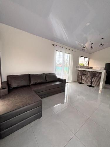 a living room with a couch and a kitchen at The Slothie's House in Tapantí