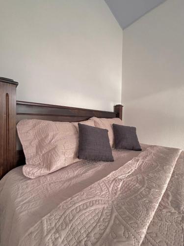 a bed with two pillows on top of it at The Slothie's House in Tapantí