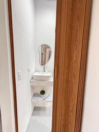 a bathroom with a sink and a mirror at The Slothie's House in Tapantí