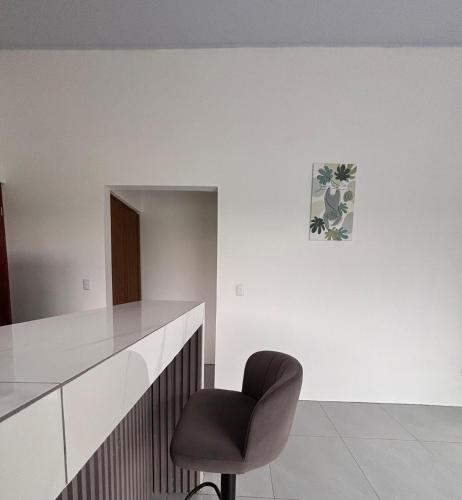 a chair in a room with a white wall at The Slothie's House in Tapantí