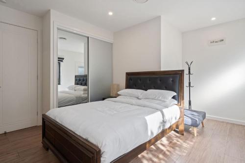 una camera da letto con un letto grande e uno specchio di Cozy Kambah 1 Bedroom Near Shops & Parks a Kambah