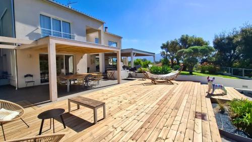 une terrasse en bois avec des chaises et un hamac sur une maison dans l'établissement VillaSerenita Piscine chauffée et SPA à Ajaccio, à Ajaccio