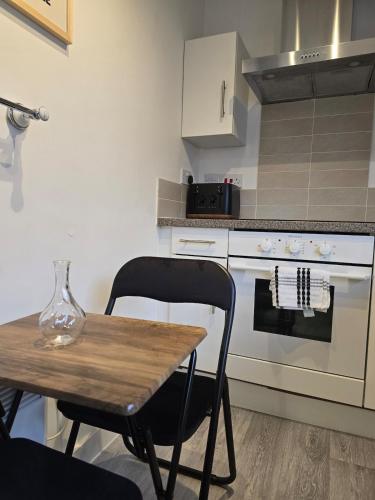 a kitchen with a wooden table and a table and a stove at Canalside 1 bed flat in Hertford