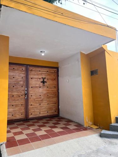 a garage with a wooden door and a checkered floor at Villa Manglar in Coveñas