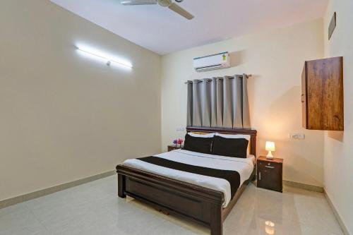 a bedroom with a bed and a ceiling fan at Super Collection O Sri Nirvana Edge in Hyderabad