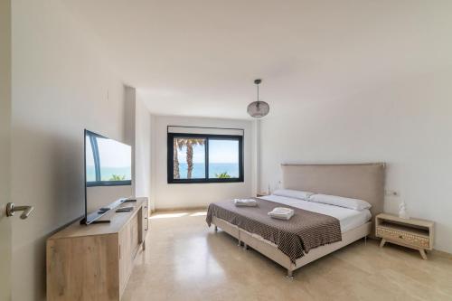 a bedroom with a bed and a desk and two windows at Chalet with sea view in Alicante in El Campello