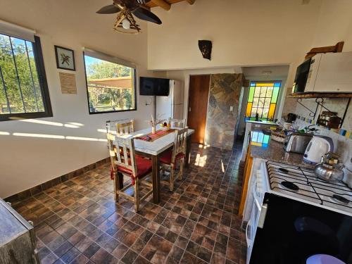 a kitchen with a table and a stove top oven at Arawi Cabaña in Merlo