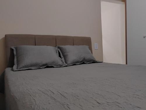 a bed with two pillows on it in a bedroom at Apartamento Mobiliado Paty do Alferes in Paty do Alferes