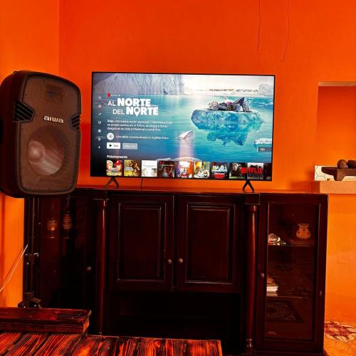 a flat screen tv sitting on top of a entertainment center at habitación triple familiar in Santa Elena