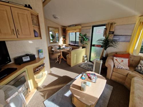 an rv living room with a couch and a table at Sea View Escape 2 Bedroom Pet Friendly Caravan at Clarach Bay Gm3 in Aberystwyth