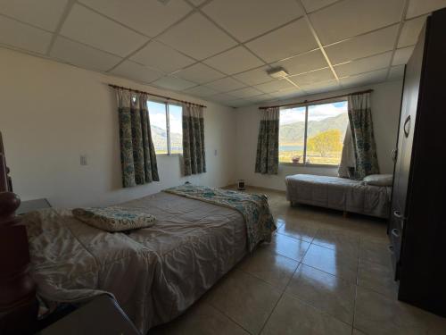 a bedroom with a bed and a couch and windows at Sueño de Tafi in Tafí del Valle