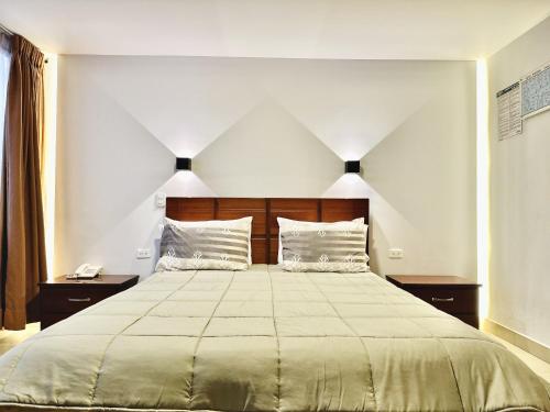 a bedroom with a large bed with two pillows at Hotel Tiwintza Internacional in Quito