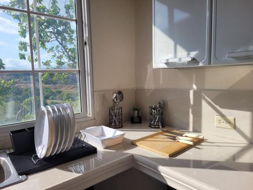 a kitchen counter with a cutting board and a window at Casa de Campo, Olá, ríos, cascadas, Los Picachos in Olá
