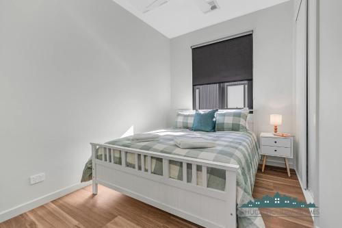 a white bedroom with a bed and a window at 58 Highview in Moama