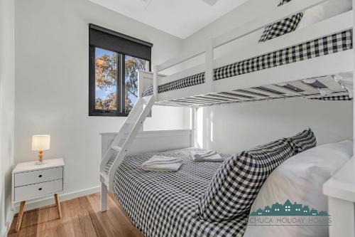 a white bedroom with a bunk bed with a ladder at 58 Highview in Moama