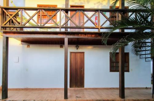 a building with a balcony and a wooden door at Pousada Pouso do Frade in Pirenópolis