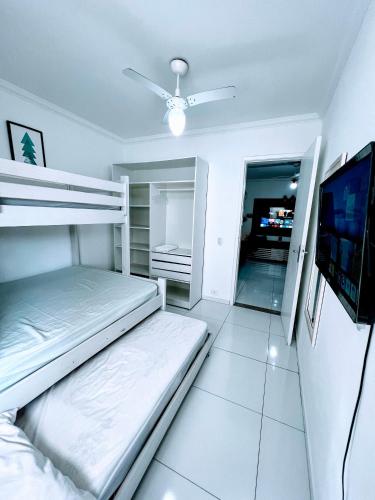 a bedroom with two bunk beds and a flat screen tv at Cobertura em Caiobá-Matinhos-Pr 2 quadras do mar in Matinhos