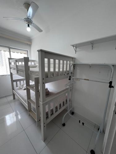 two bunk beds in a room with a ceiling fan at Cobertura em Caiobá-Matinhos-Pr 2 quadras do mar in Matinhos