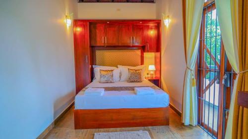 a bedroom with a bed with a wooden headboard at Serene Villa Airport Transit in Katunayake
