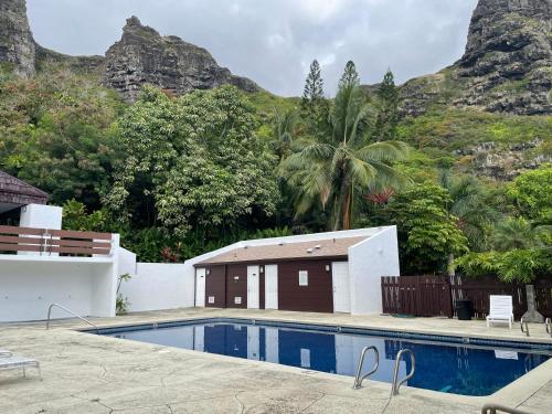 a swimming pool in front of a mountain at Oceanview Condo with Loft & AC in Kaaawa