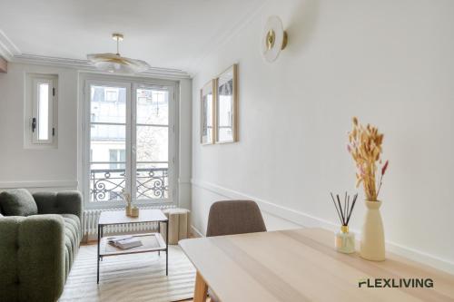 un salon avec une table et des chaises et une fenêtre dans l'établissement Charming 2-bedroom with living room 47 m Paris 9e, à Paris
