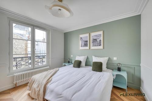une chambre avec un grand lit et une fenêtre dans l'établissement Charming 2-bedroom with living room 47 m Paris 9e, à Paris