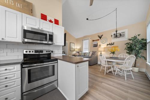 a kitchen with white cabinets and a stove top oven at Le Wapiti - 75 Butternut in Cherry Valley