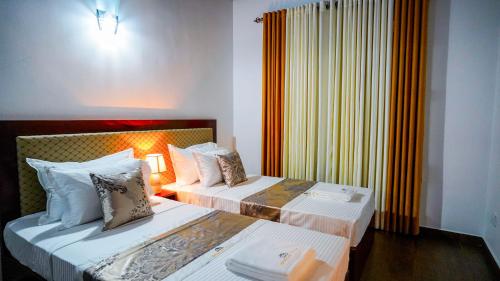 a hotel room with two beds and a window at Serene Villa Airport Transit in Katunayake