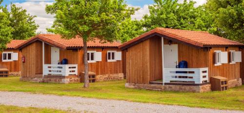 a row of wooden cottages in a park at Camping Cantabria in Polientes