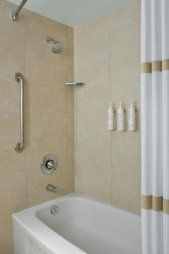 a bathroom with a bath tub with a shower curtain at Halifax Marriott Harbourfront Hotel in Halifax