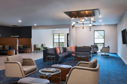 a living room with a couch and chairs and tables at Courtyard Houston The Woodlands in The Woodlands