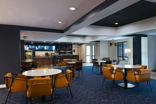 a restaurant with tables and chairs and a bar at Courtyard Houston The Woodlands in The Woodlands