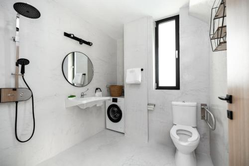 a white bathroom with a toilet and a sink at Flamingo Living Halkidiki - The Villas in Áyios Mámas