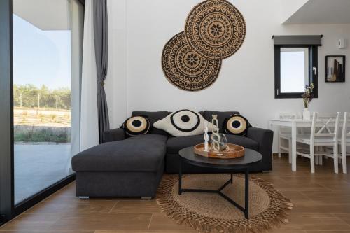a living room with a couch and a table at Flamingo Living Halkidiki - The Villas in Áyios Mámas